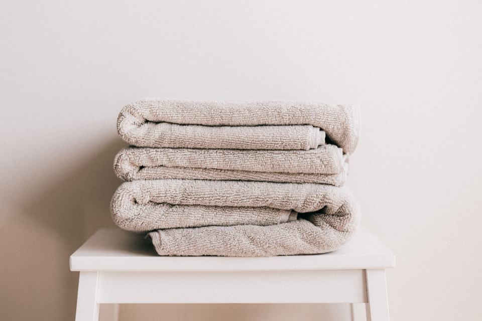 Serviettes de toilette pliées sur un tabouret blanc